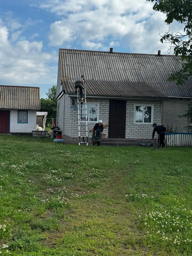 Майстер на покрівлі будинку